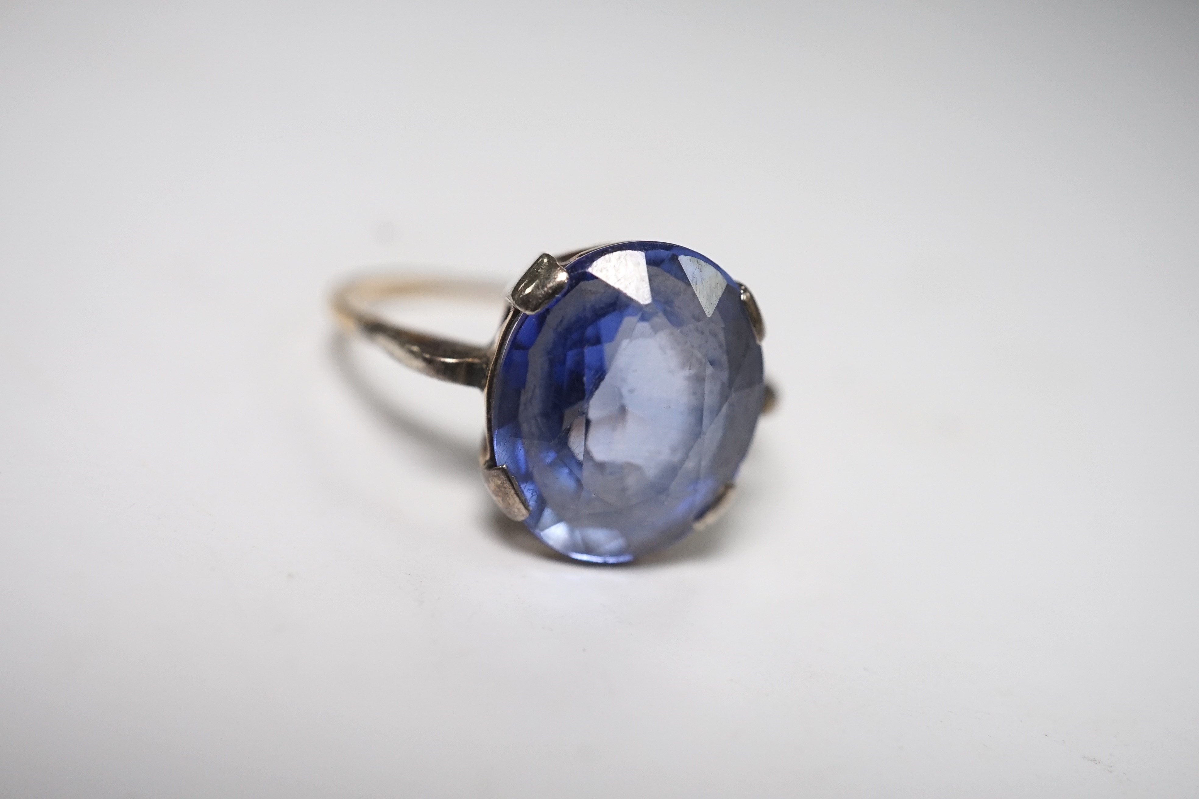 A yellow metal and single stone oval cut synthetic? sapphire set ring, size N, gross weight 2.8 grams. Condition - poor to fair